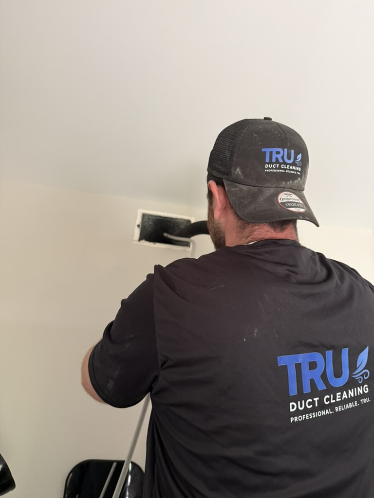 Tru Duct Cleaning technician cleaning air duct vent
